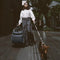 Woman walking with stylish green dog travel carrier and leash