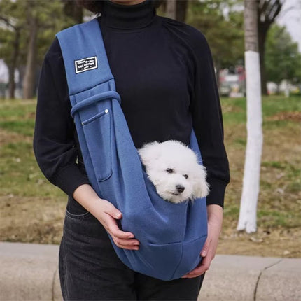 Cute puppy in dog sling carrier for outings