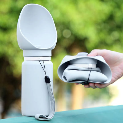 Foldable dog water bottle being held next to fully extended version with carrying strap, perfect for on-the-go hydration